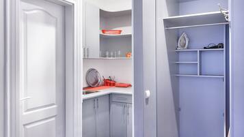 Een moderne keuken met een wit aanrecht, een spoelbak en een rode mand.