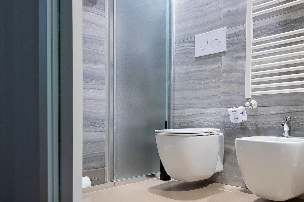 A modern bathroom with a toilet, bidet, and sink.