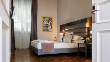 A hotel room with a bed, bedside table, and a wall-mounted artwork.