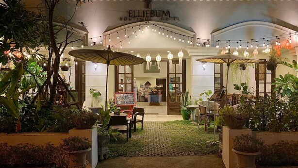 The exterior of Ellijium Boutique Hotel with a well-lit entrance, outdoor seating area, and string lights. - Elliebum Boutique Hotel (Chiang Mai)