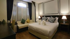 A hotel room with a bed, a sofa, a desk, and a nightstand. - Elliebum Boutique Hotel (Chiang Mai)