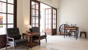A room with two leather chairs, a wooden table with a lamp, and a small wooden stool. - Elliebum Boutique Hotel (Chiang Mai)