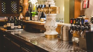 A bar area with a tap station, a coffee machine, and various bottles of wine. - Zum Vater Rhein (Monheim)