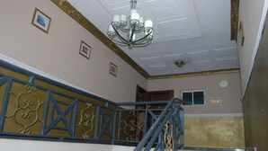 A staircase with blue railings and a chandelier. - GQ International Hotel (Abuja)