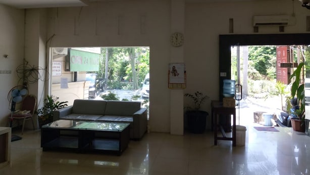 Eine geräumige Lobby mit einer Couch, einem Couchtisch und einer Wanduhr.
