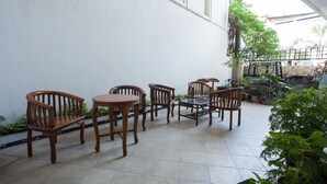 Eine Terrassenfläche mit Holzmöbeln und Topfpflanzen.