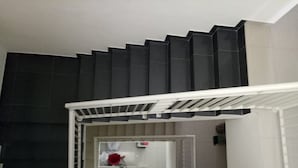 Eine Treppe mit dunklem und hellem Boden, die zu einer Zwischenebene führt, auf der sich ein rotes Objekt auf einem Tisch befindet.