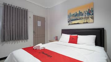 A hotel room with a bed, a cityscape painting, a door, and a window with curtains.
