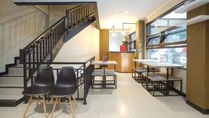 A modern interior with a staircase, seating area, and a counter. - Reddoorz Near Botani Square Mall (Bogor)