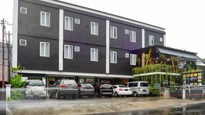 A multi-story building with a parking lot in front. - Reddoorz Near Botani Square Mall (Bogor)