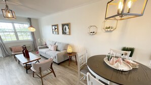 Un salon moderne comprenant un canapé, une table à manger, des chaises et des objets de décoration.