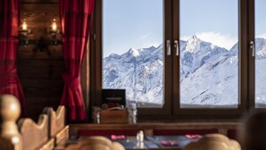 A restaurant with a view of snow-covered mountains through large windows. - Hotel Schwarzsee (Zermatt)