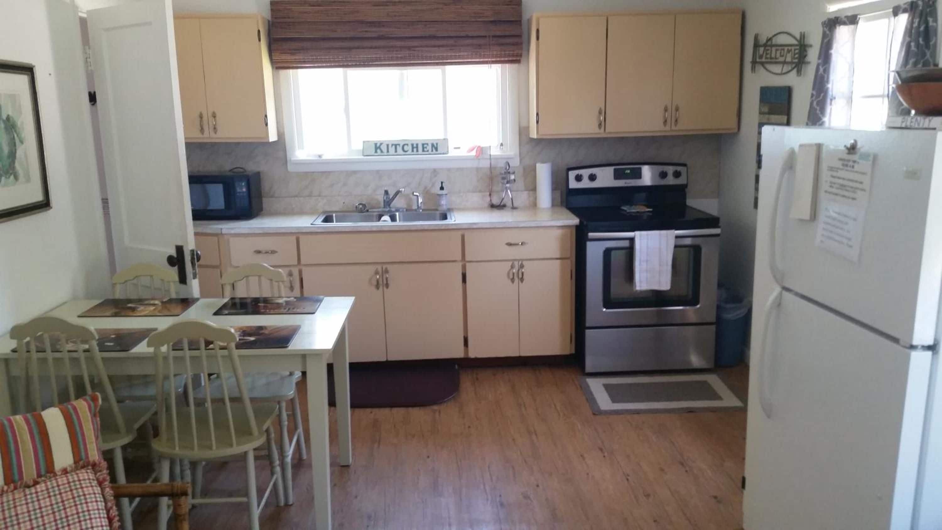 Cocina compacta con estufa, horno, lavaplatos y refrigerador.