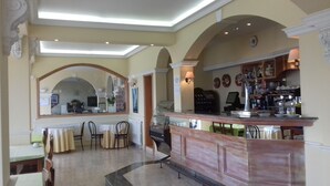 A bar area with a counter, seating, and a mirror. - Hotel Rompeolas (Baiona)