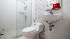 Une salle de bain moderne équipée de toilettes, d’un lavabo et d’une douche.