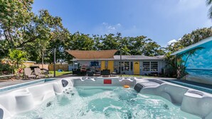 A hot tub area with a pool, lounge chairs, and a building with a mural. - Hollywood Castle Palace (Hollywood)