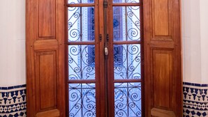 A wooden door with glass panels and intricate metalwork. - Dar Settash (Fes)