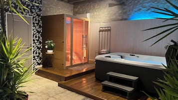 Relax in a serene spa room with a hot tub and separate sauna area.