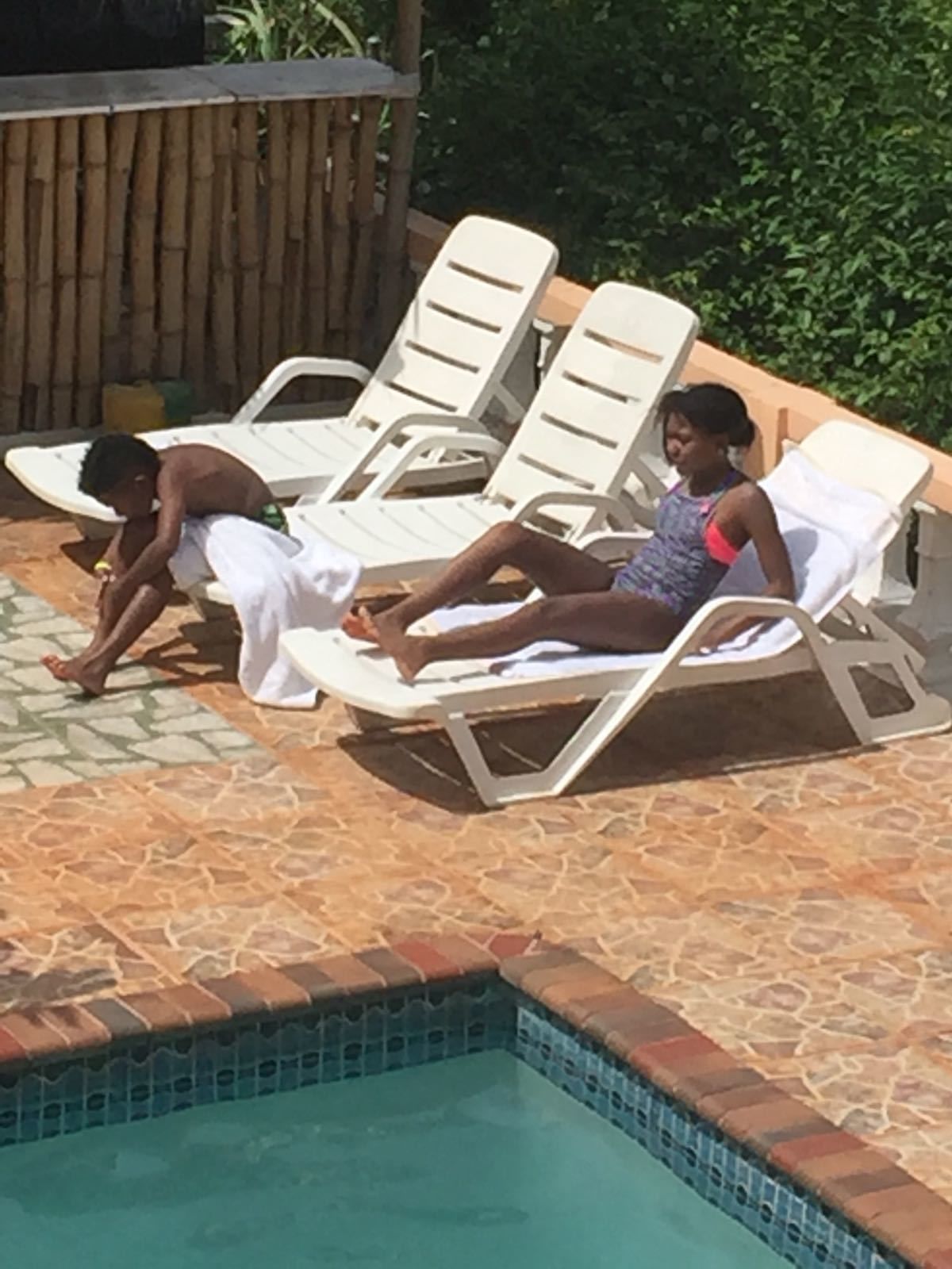 A poolside area with lounge chairs and a tiled pool.
