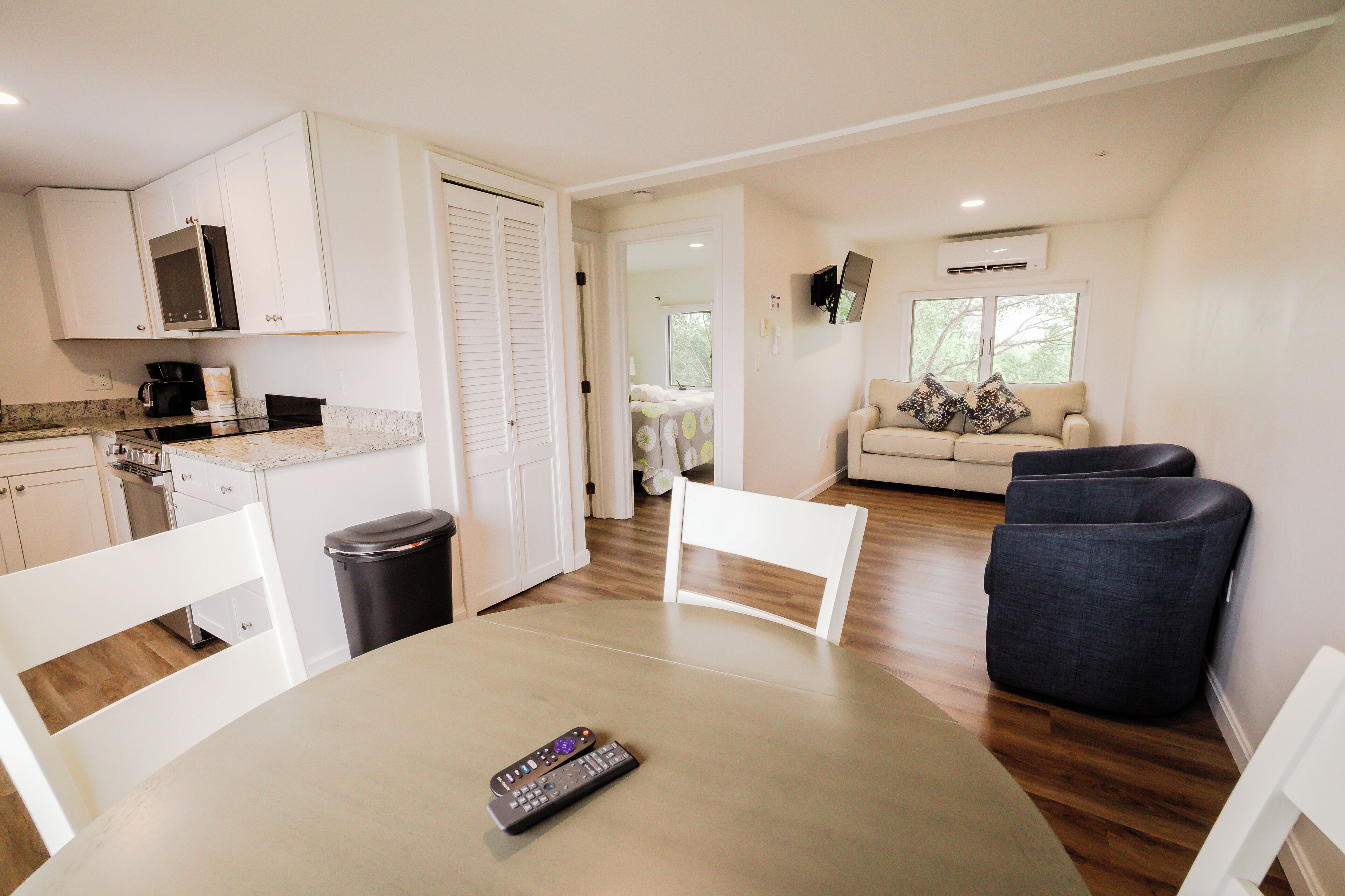 A compact living space with a kitchen, dining area, and a seating area with a couch and chairs.
