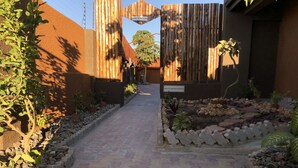 Un camino pavimentado que conduce a una zona de recepción, con un cartel que indica 'RECEPTION' y 'RIGHT OF ADMISSION RESERVED'.