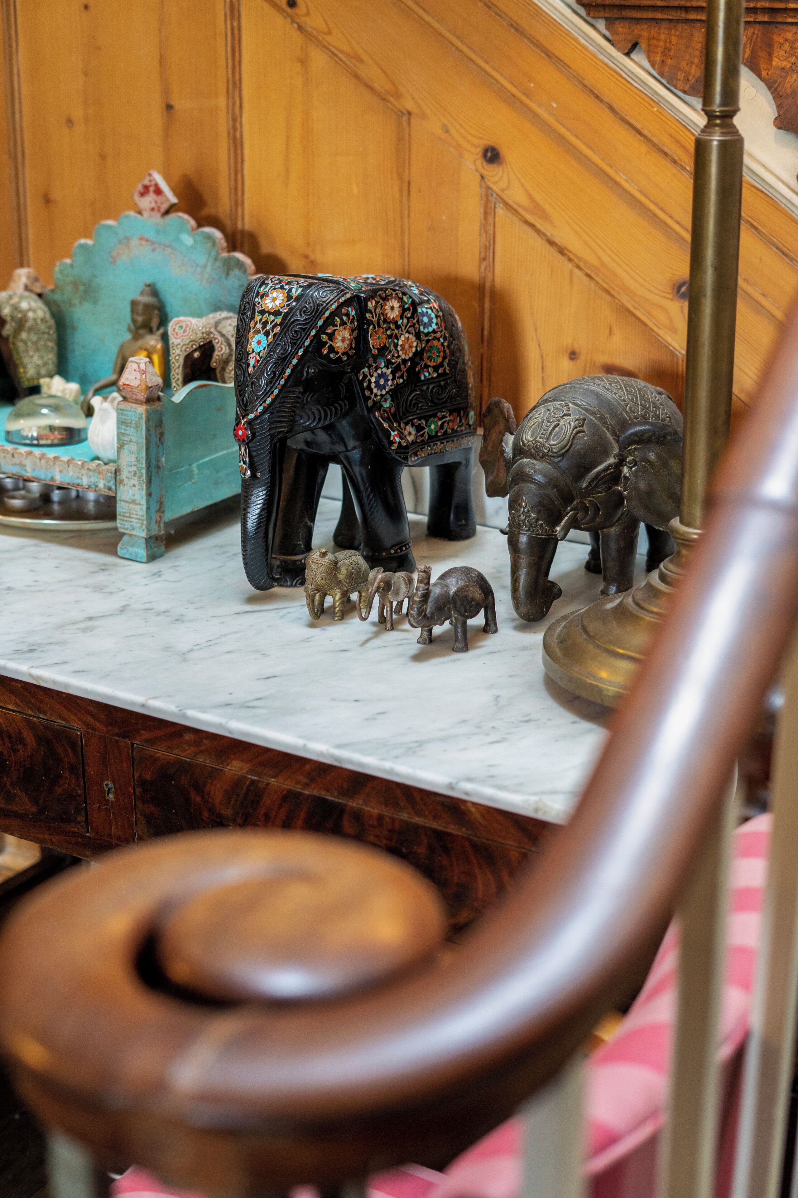 A marble countertop with decorative elephant figurines and a brass lamp.