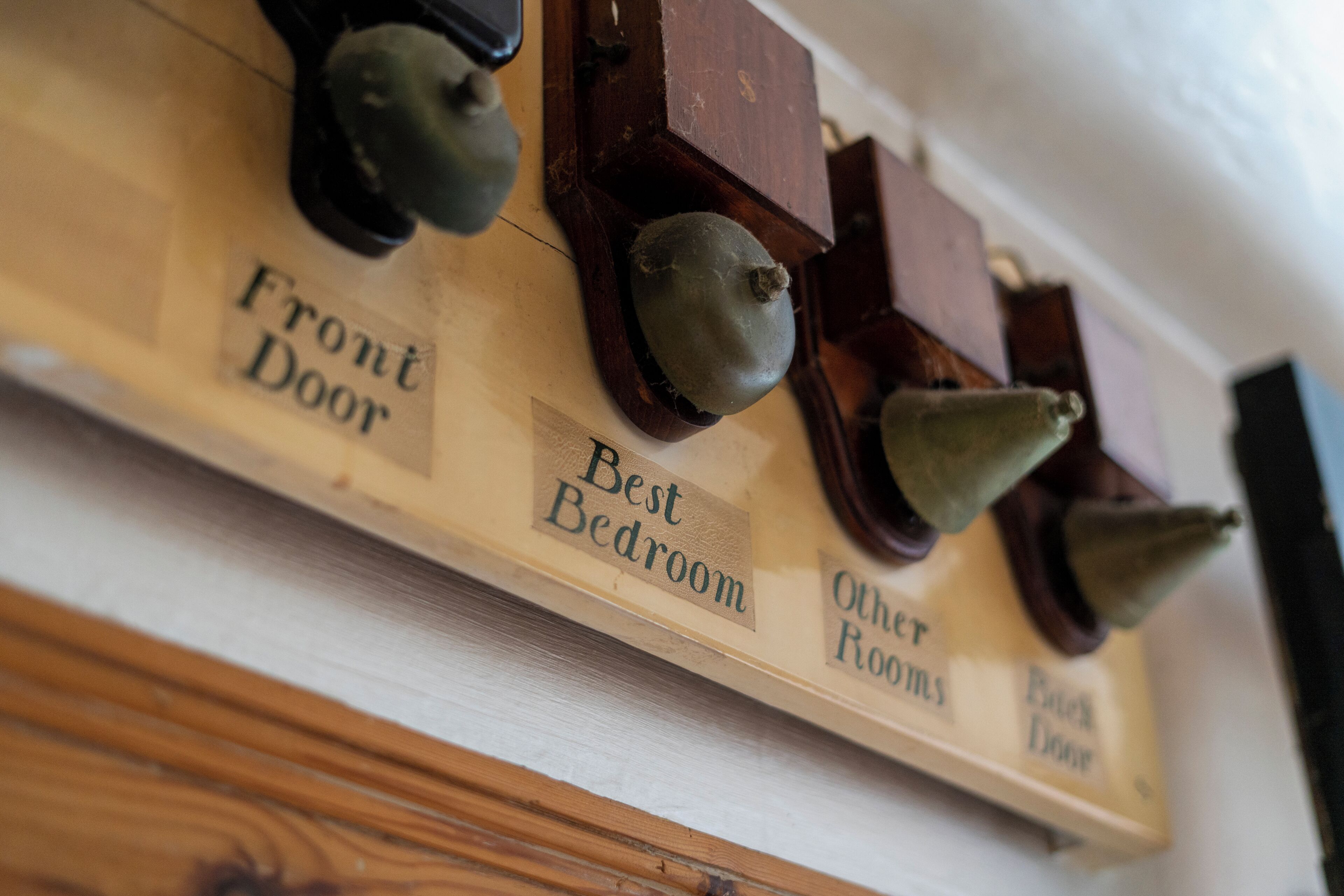 A wall-mounted control panel with labels for 'Front Door,' 'Best Bedroom,' 'Other Rooms,' and 'Back Door.'