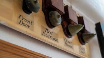 A wall-mounted control panel with labels for 'Front Door,' 'Best Bedroom,' 'Other Rooms,' and 'Back Door.'