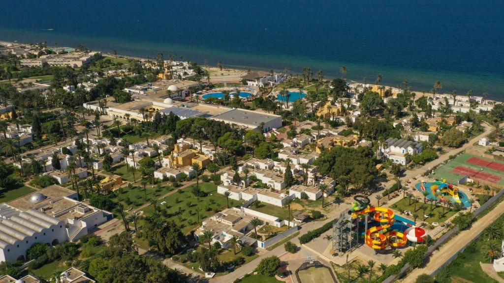 Vista aérea de una zona residencial costera con varios edificios, una piscina grande y un parque acuático.