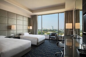 Enjoy a city view from the large window in this stylish room with two single beds and a cozy seating area.