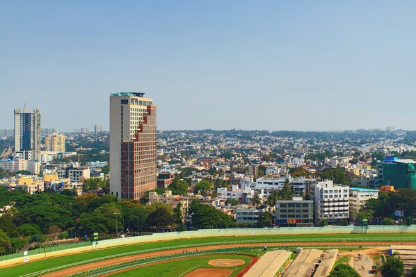 Panoramic city views surround a sports field and modern buildings.