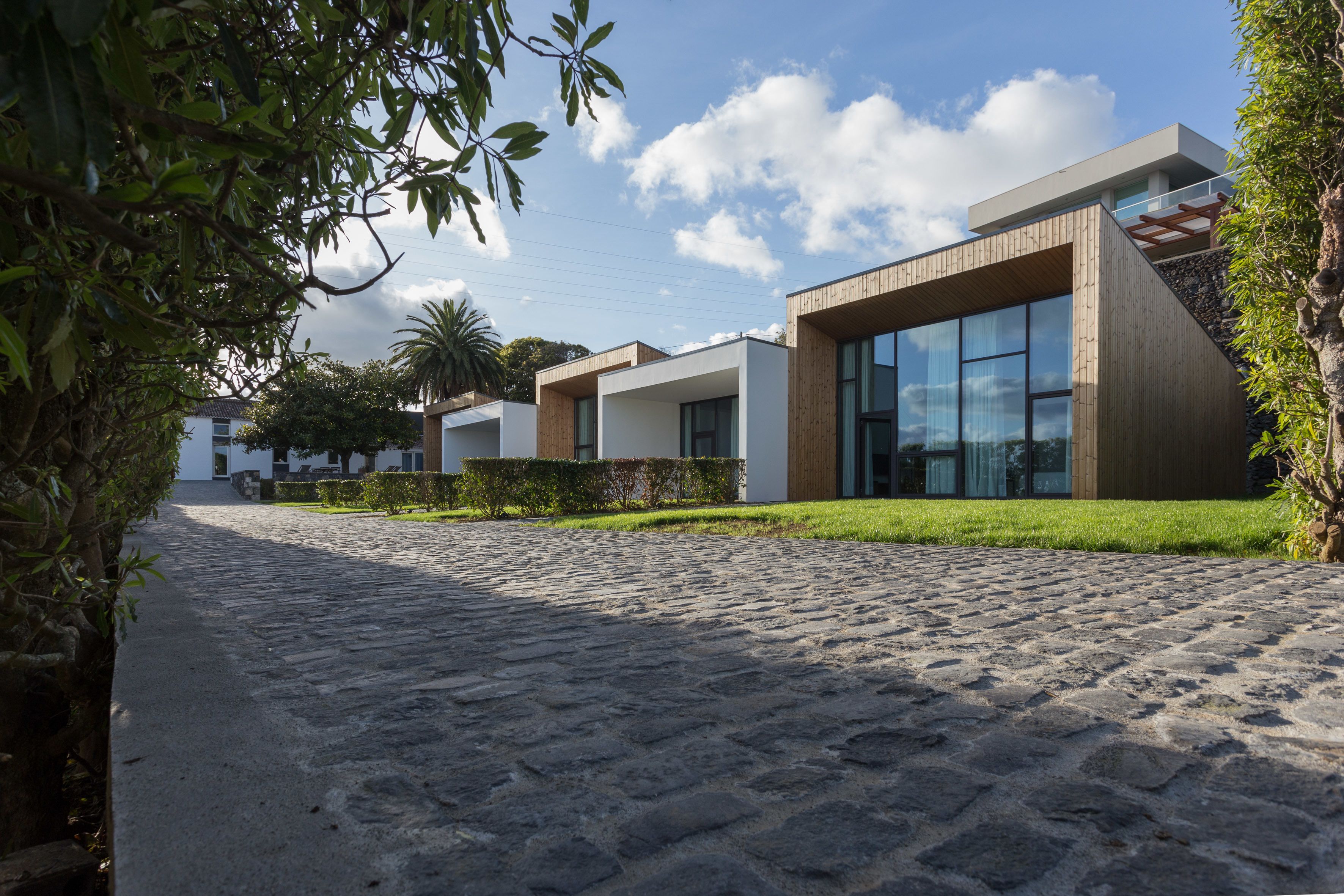 A modern building with large windows and a stone-paved entrance.