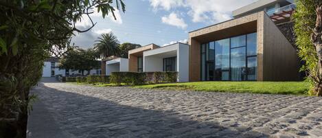 A modern building with large windows and a stone-paved entrance.