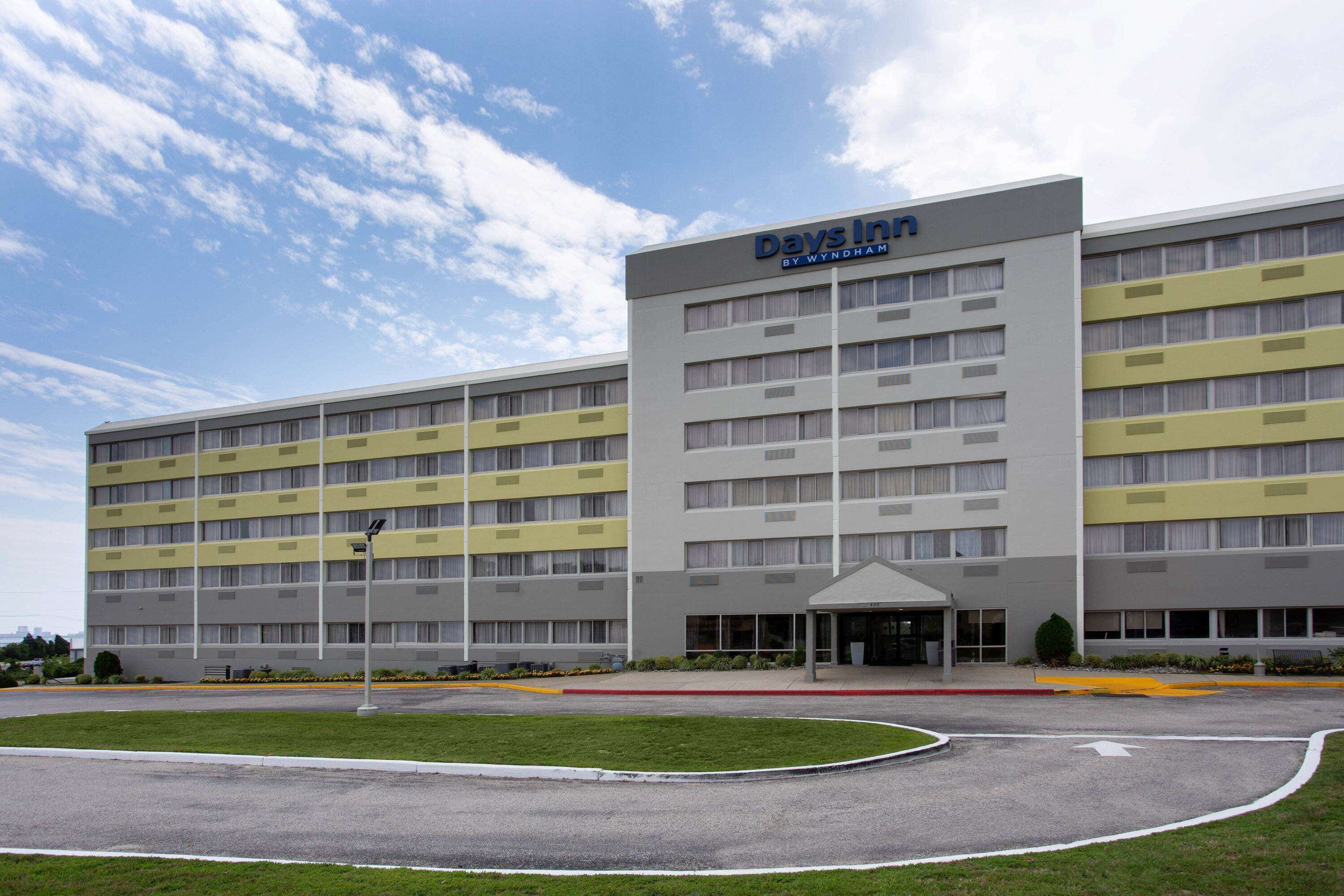 A Days Inn by Wyndham hotel with a modern design, featuring a large entrance and a covered waiting area.