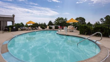 Una piscina al aire libre de temporada, sillones reclinables de piscina