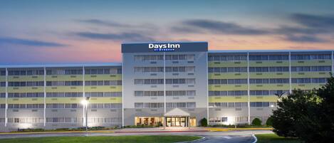 A Days Inn hotel with a modern design, featuring a central entrance and multiple floors.