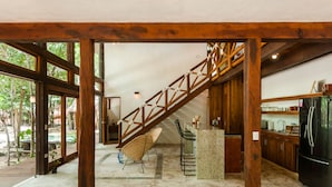 Una cocina amplia con una escalera de madera, una barra y vistas al exterior.