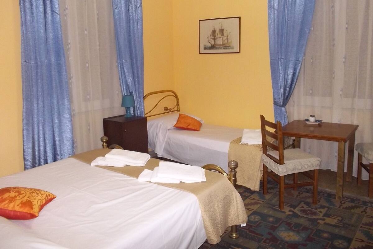 Una habitación con dos camas, un escritorio y una silla.