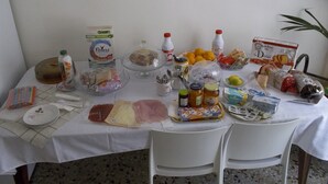 Una mesa dispuesta con diversos alimentos, como pan, frutas y salsas.