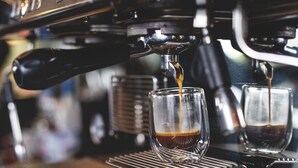 An espresso machine dispensing coffee into a glass cup.