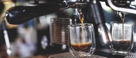 An espresso machine dispensing coffee into a glass cup.