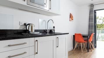 Suite, 1 tweepersoonsbed met slaapbank, keuken | Woonruimte | Een 19-inch televisie met digitale zenders