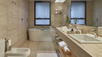 A modern bathroom with a freestanding bathtub, a double sink vanity, and a bidet.