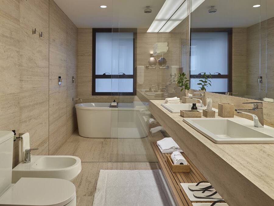 Uma casa de banho moderna com uma banheira independente, um lavatório duplo e um bidé.