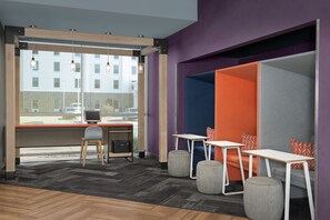 A modern office space with a desk, computer, and seating area. - Tru by Hilton Fayetteville I-95, NC (Fayetteville)