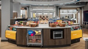 A self-service beverage station with a refrigerated display and a microwave. - Tru by Hilton Fayetteville I-95, NC (Fayetteville)