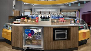 A self-service beverage station with a refrigerated display, a microwave, and a variety of drinks. - Tru by Hilton Fayetteville I-95, NC (Fayetteville)