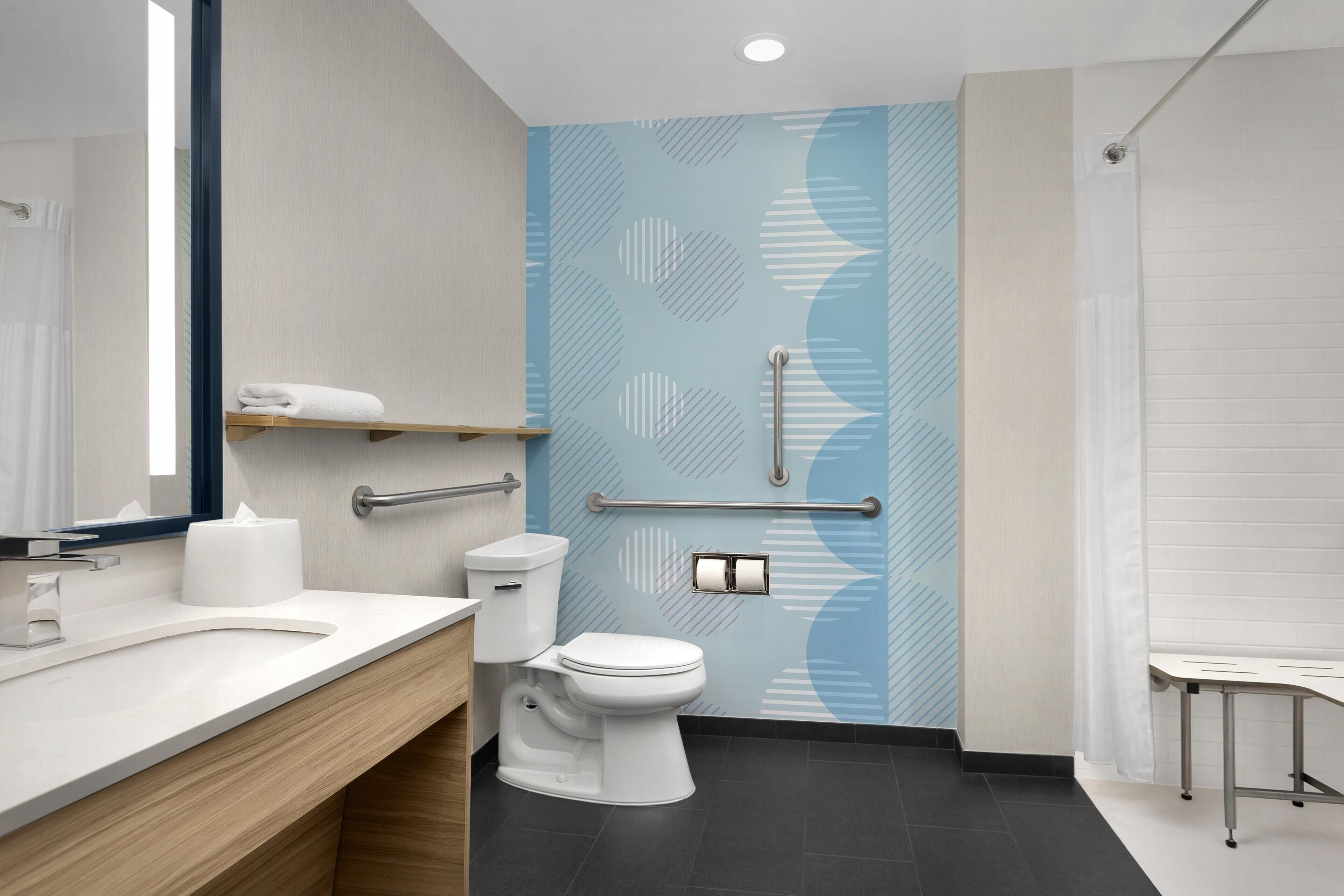 A modern bathroom with a white sink, toilet, and shower area.