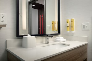 A modern bathroom with a white sink, a mirror, and two yellow soap dispensers. - Tru by Hilton Fayetteville I-95, NC (Fayetteville)