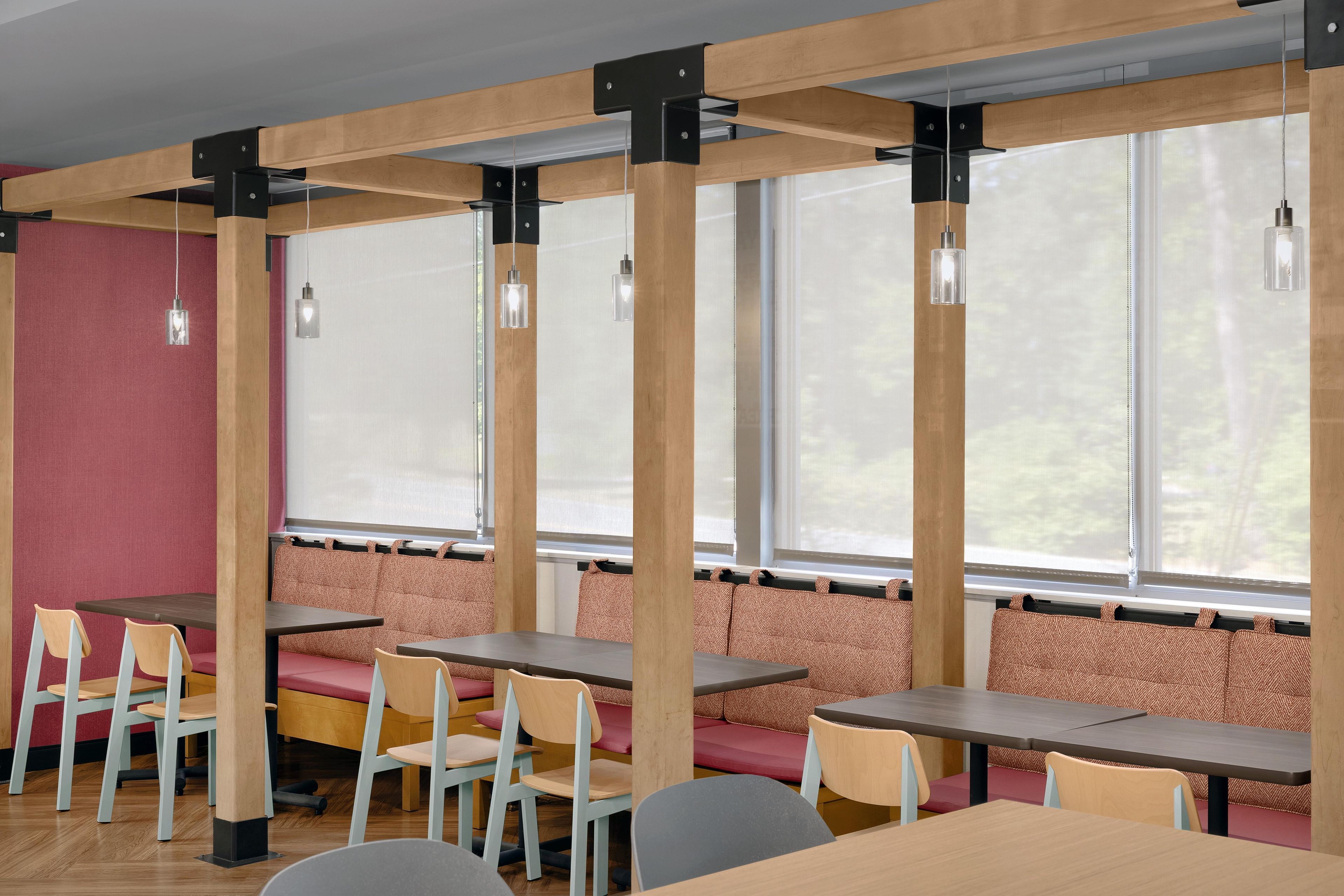 Comedor con vigas de madera, asientos acolchados e iluminación colgante.